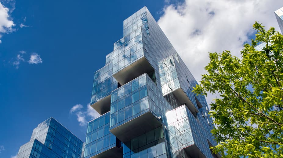 Exterior Top Portion View of 420 Kent Building with Blue Sky and White Clouds