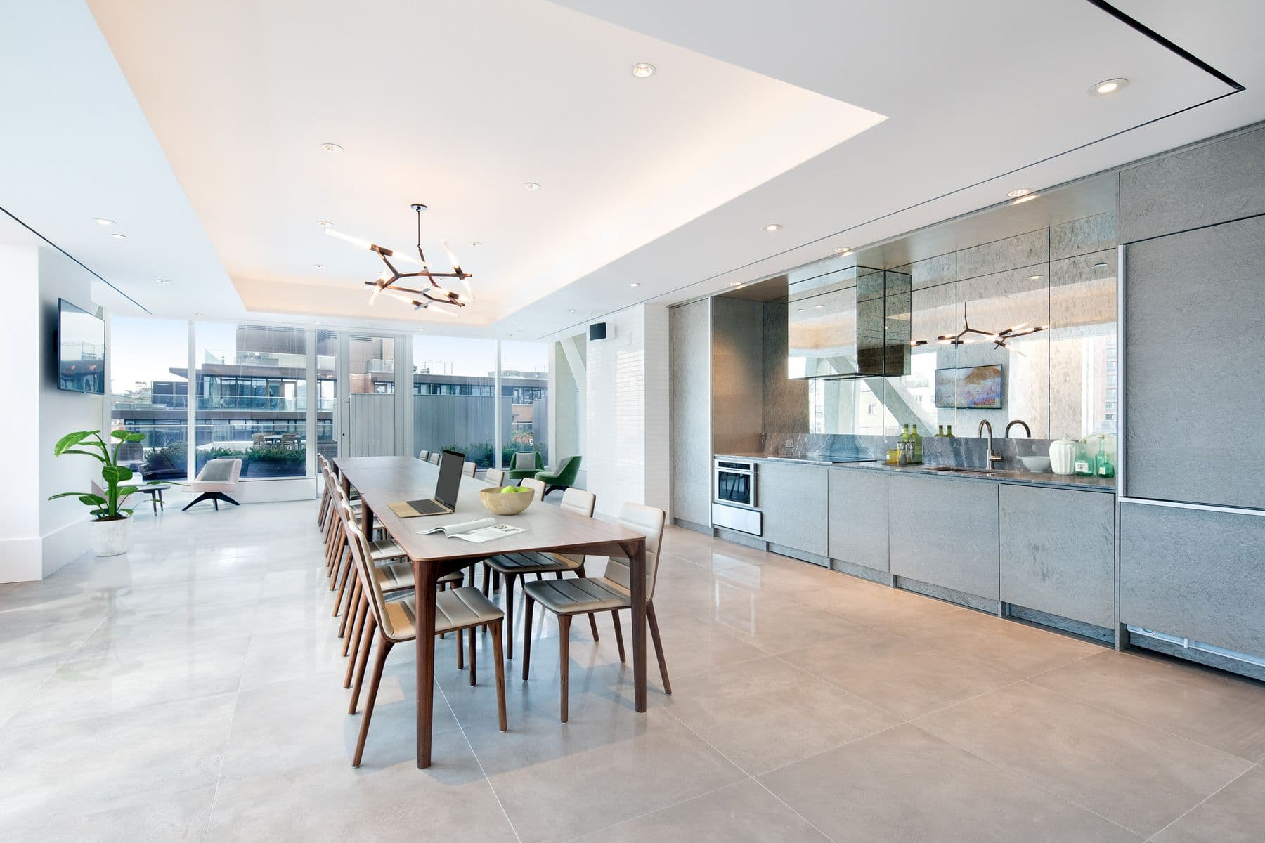 420 Kent - Coworking lounge with long conference table and charis, modern, open kitchen, large tiled flooring, large windows, bright and spacious