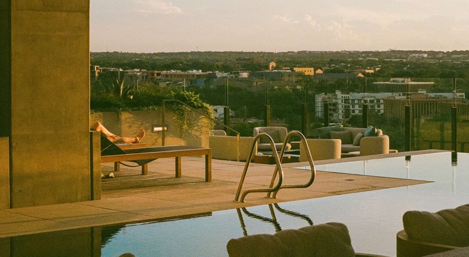 swimming pool with lounge chairs and a view of a city