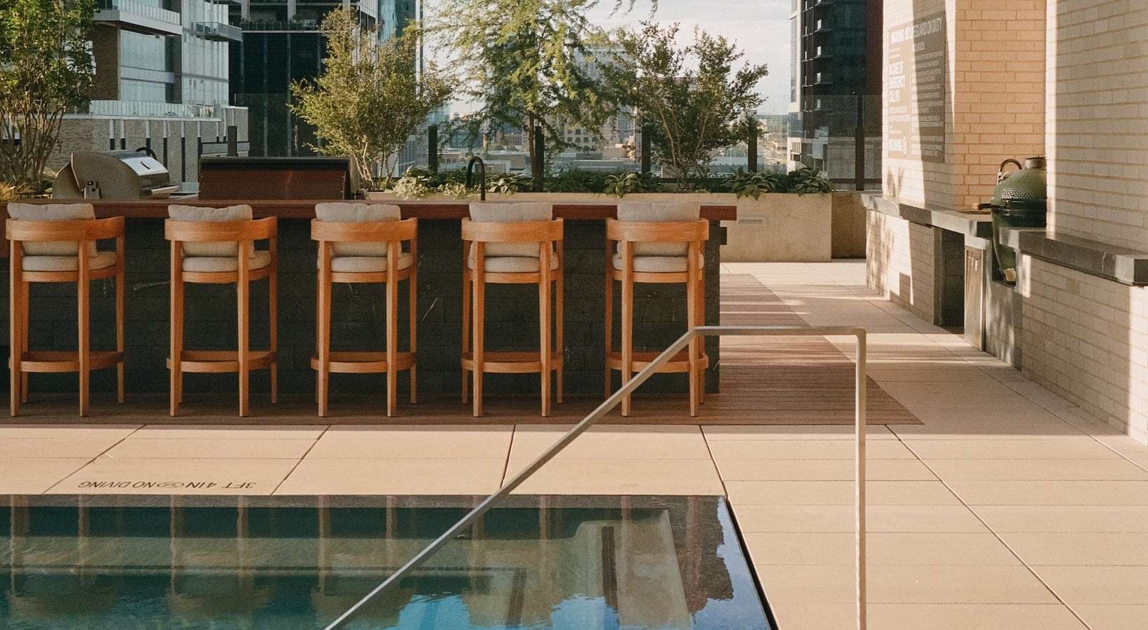 swimming pool next to a bar with bar stool