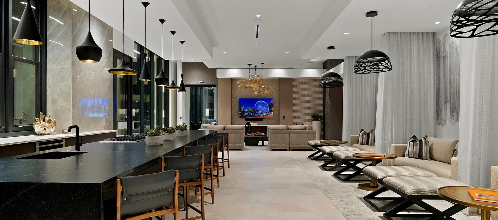 Elegant open-concept lounge with modern pendant lights, sleek seating, and a luxurious marble counter.