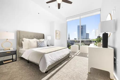 A bedroom with a large bed and a view of the city.