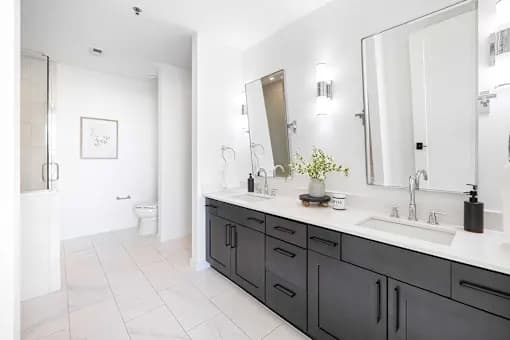 A bathroom with a white sink and a large mirror.