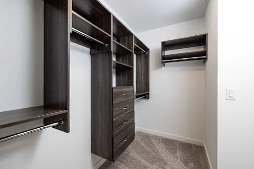 A walk-in closet with drawers and shelves.