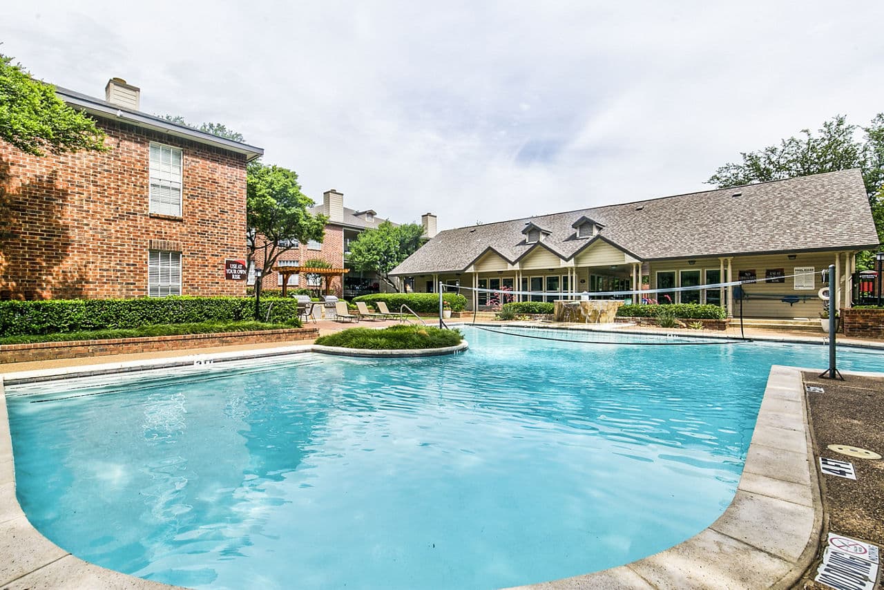 Resort-style pool surrounded by palm trees at The Georgian Apartments, a Greystar luxury community
