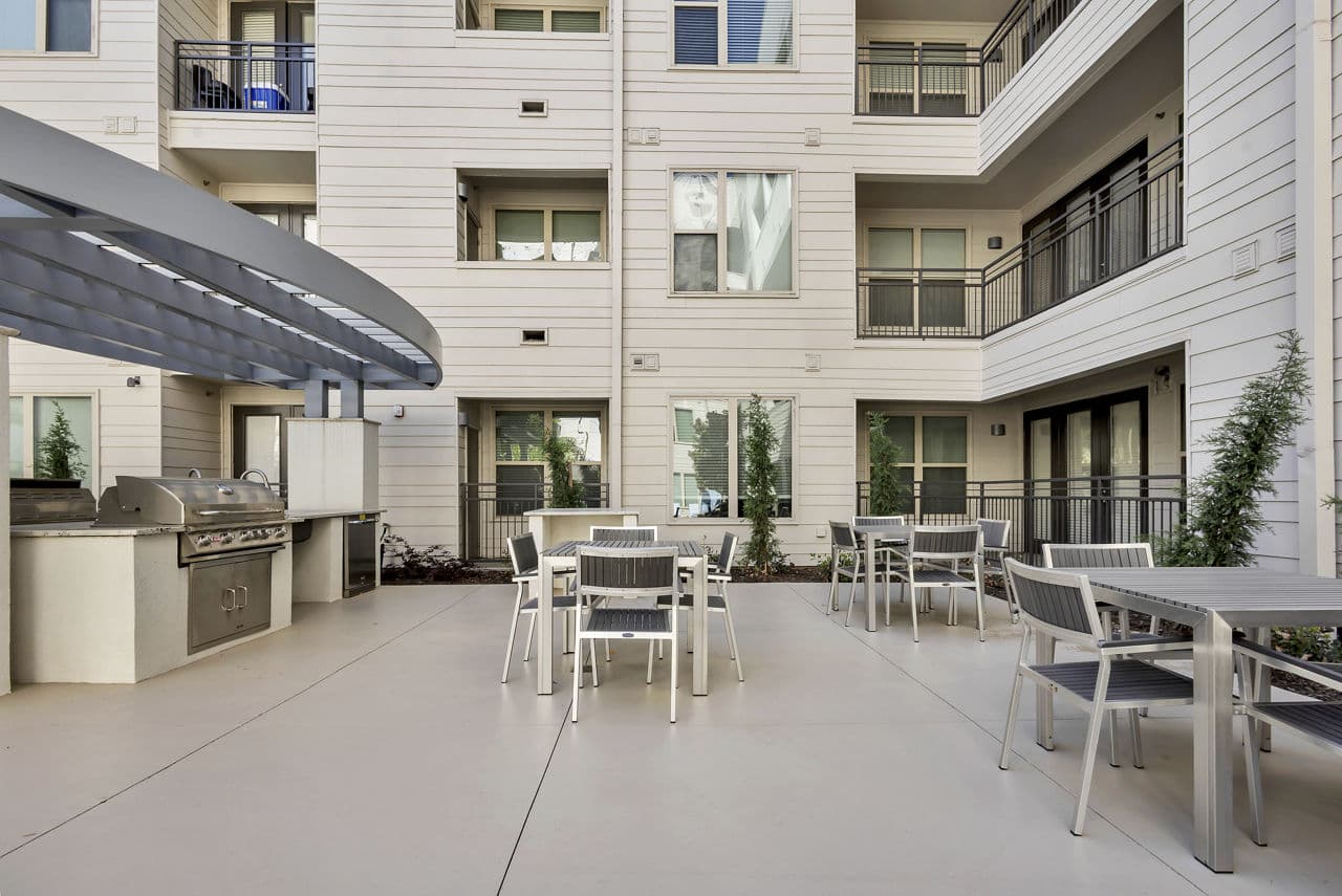 Spacious outdoor grill area with modern seating at Oak & Ellum Apartments