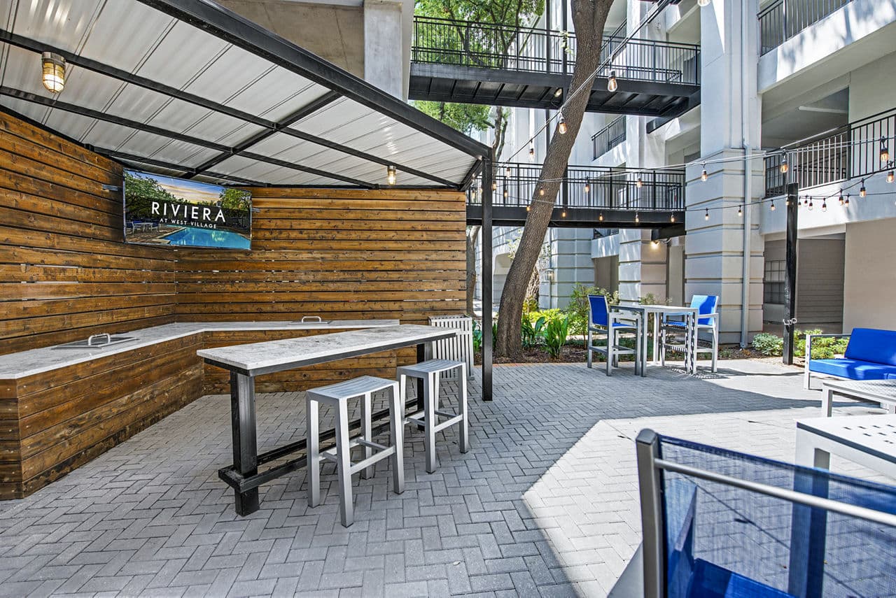 Private patio with stylish seating at Riviera at West Village Apartments, offering outdoor relaxation in a luxury setting