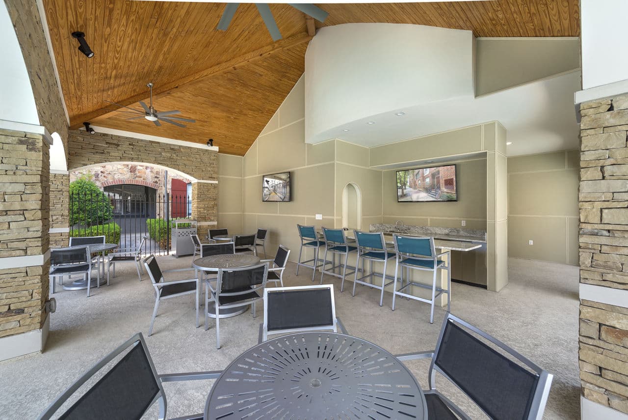 Manchester State Thomas: Chic patio area with modern seating and lush greenery, offering luxury living in an urban Dallas apartment setting