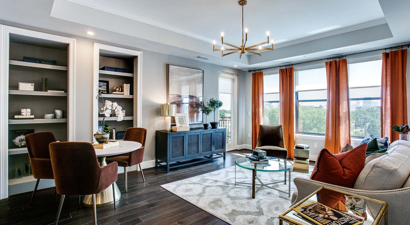 Spacious living room features built-in bookshelves and plenty of large windows