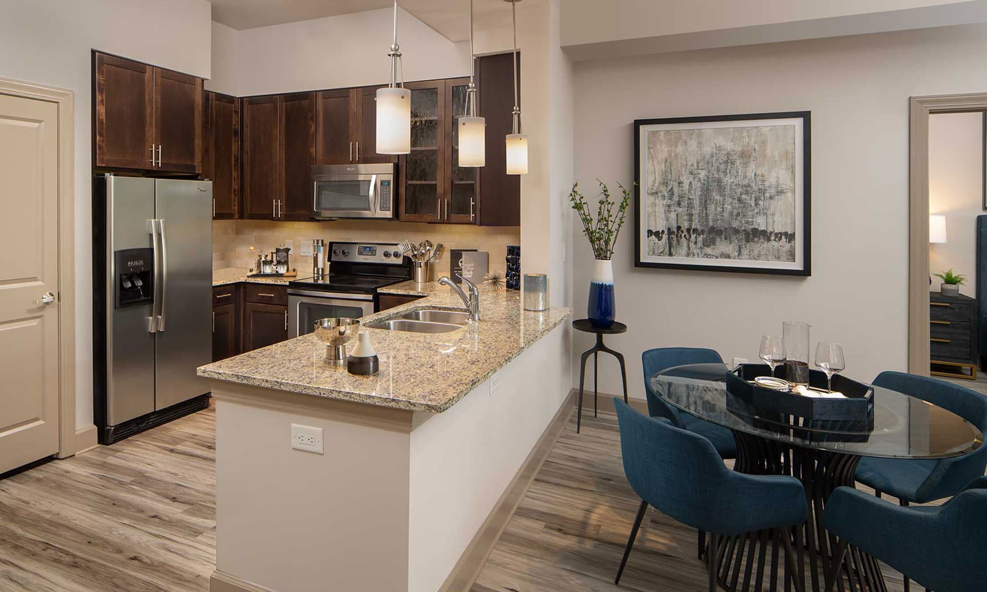 Kitchen with stainless steel appliances, dining area with table, granite counters and double basin sink