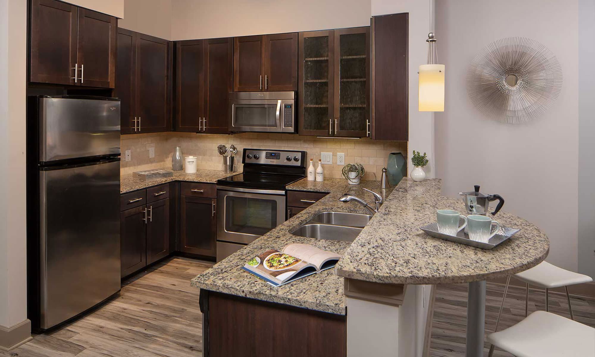 Kitchen with granite counters, custom cabinetry, and stainless steel appliances