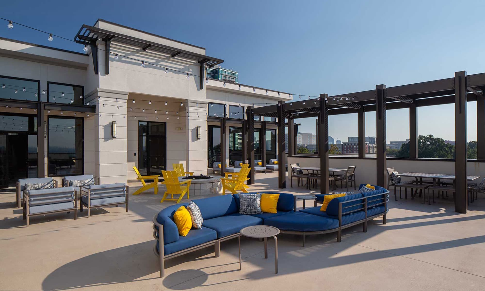 Rooftop area with patio lights, plush seating, and fire pit