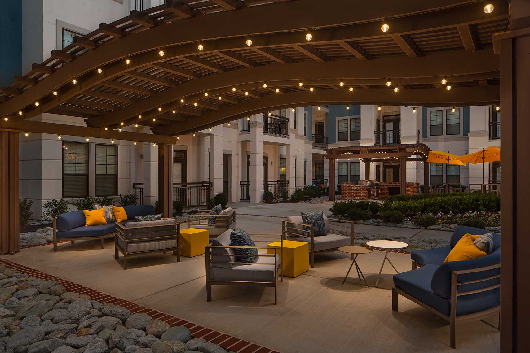 Outdoor covered seating with patio lighting, community grills, umbrellas and plush lounge furniture