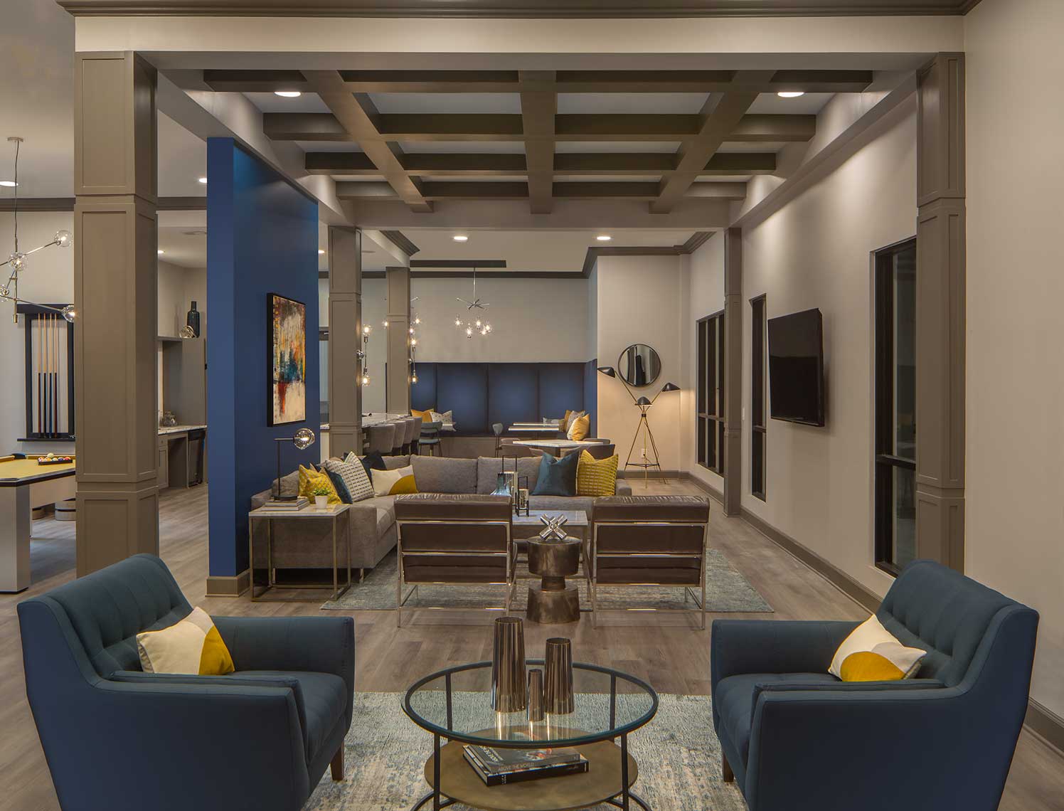 Clubhouse room with wall mounted TV, accent walls, pool table, lounge seating and bar seating