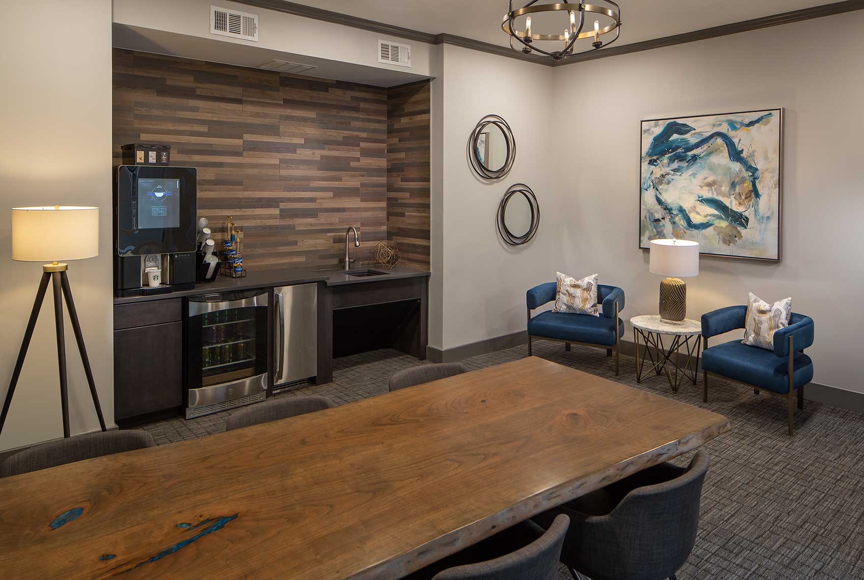 Community room with coffee station, conference table and chairs, and mini fridge