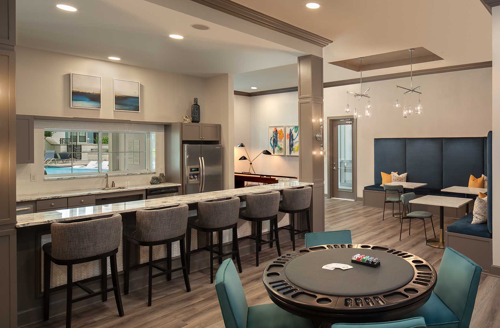 bar area with kitchen, poker table, corner seating with tables, and decor