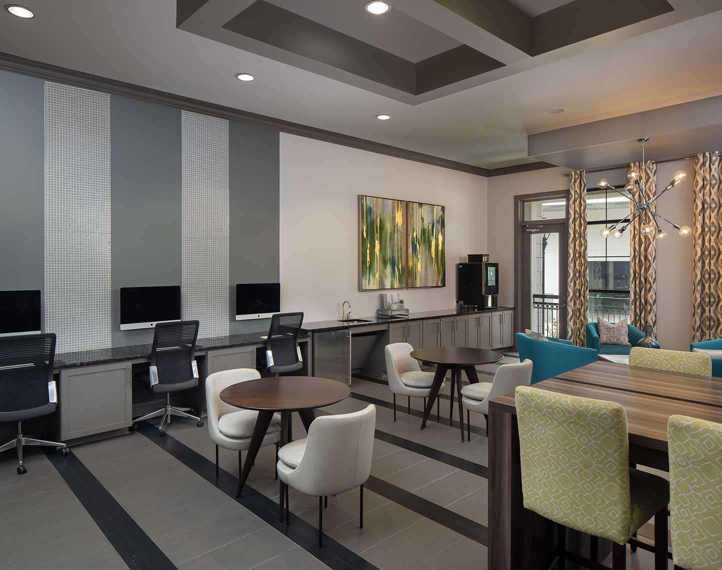 lounge area with imac computers, coffee machine, and various tables and seating areas.