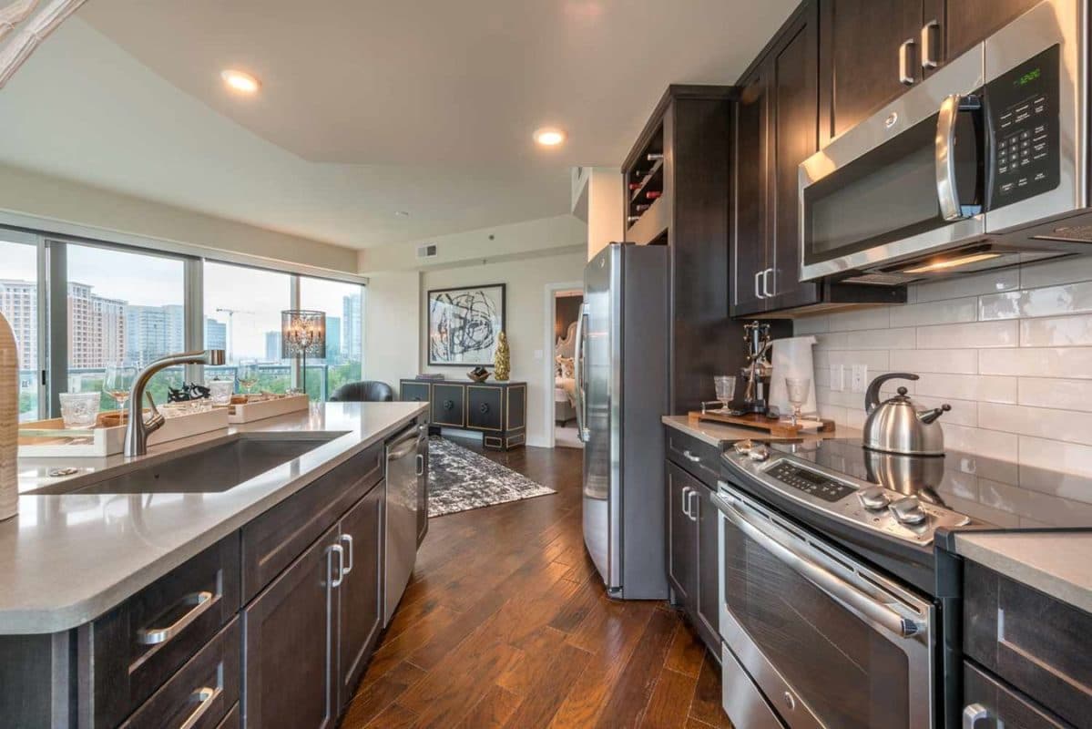 Spacious living room and kitchen with dark cabinetry and quartz counters