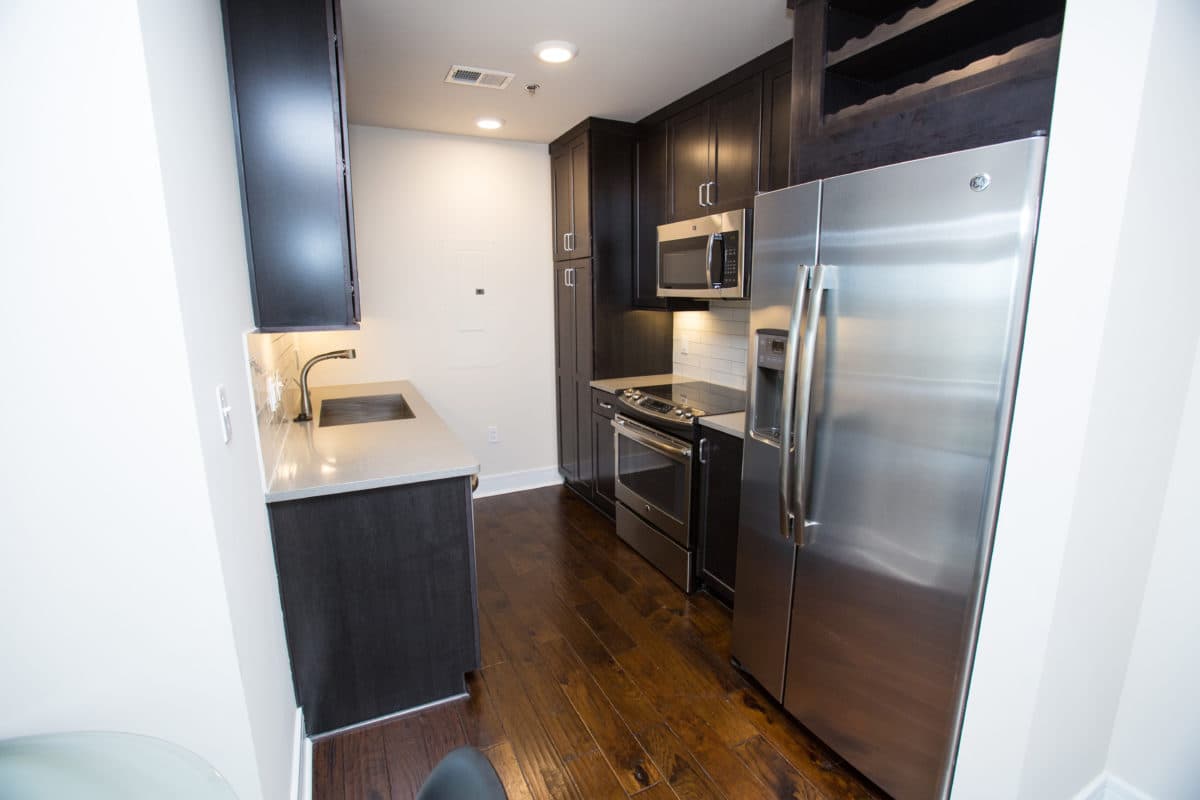 Kitchen with stainless steel appliances and dark cabinetry