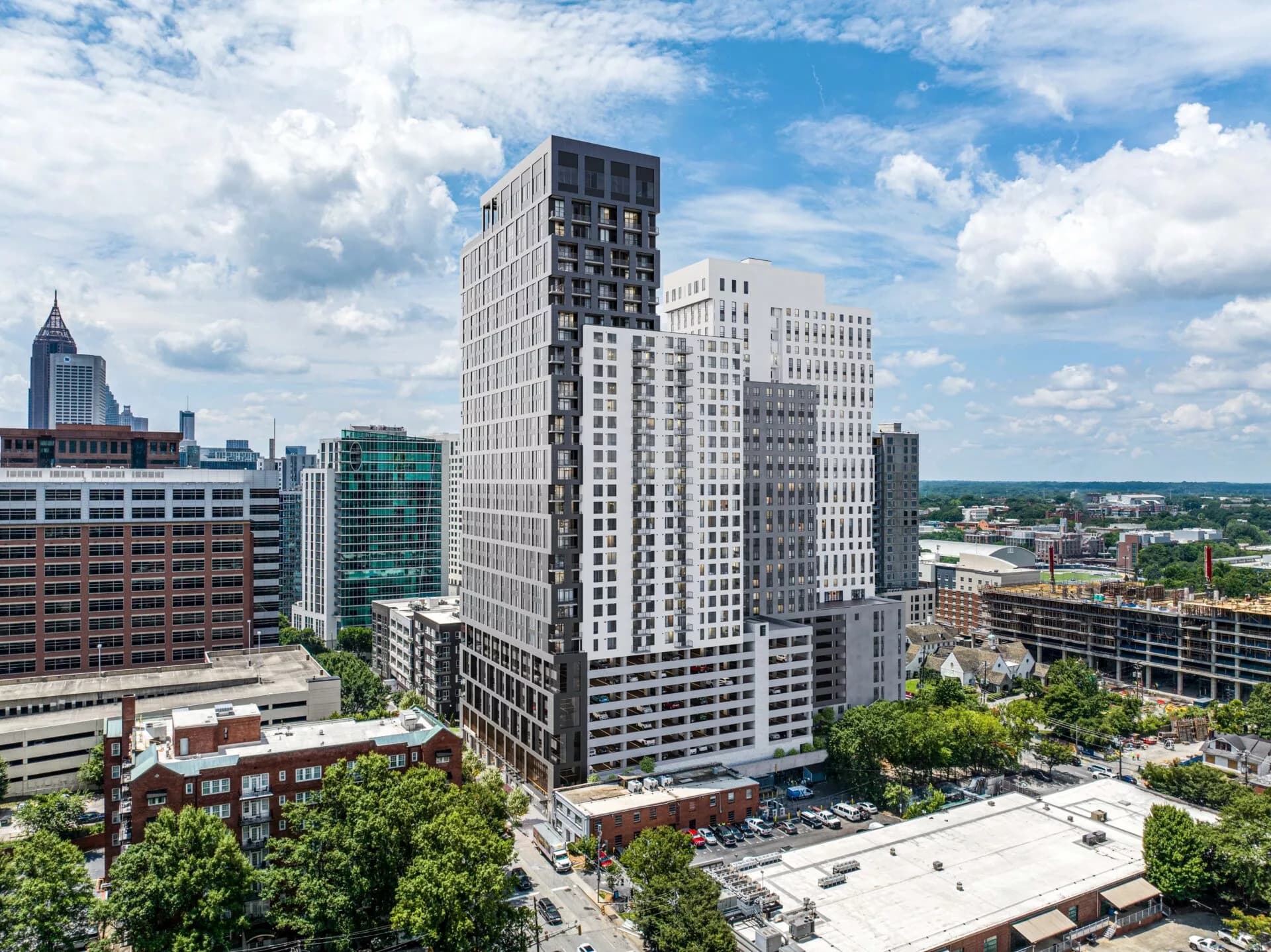 A modern high-rise apartment building with sleek glass windows, viewed during the day.