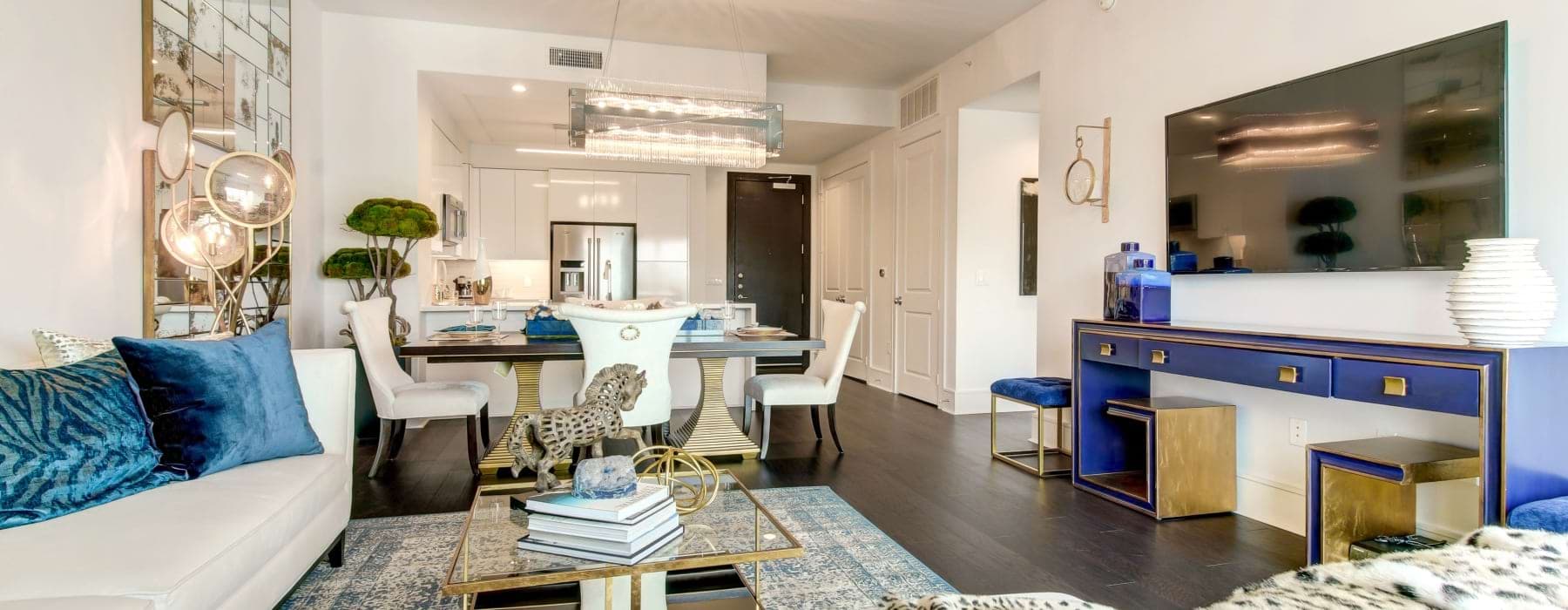 Cirque Residences downtown Dallas apartment that is fully furnished showing the living room, dining room, and kitchen in a spacious open layout.