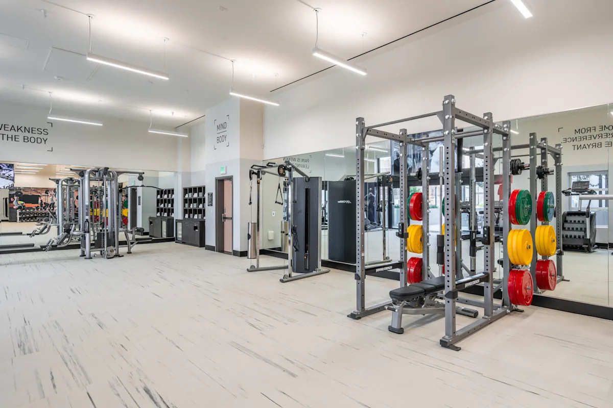 a gym with fitness equipment and mirrors on the wall at SMB Hollywood Apartments, Los Angeles