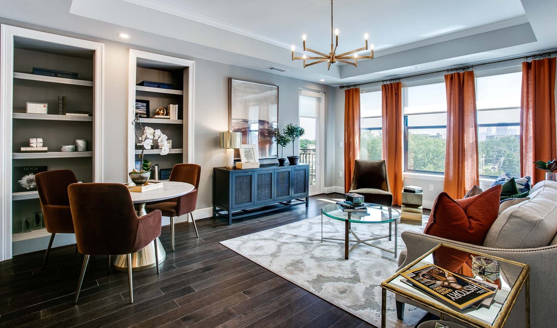 Living features multiple large windows and built-in bookcases
